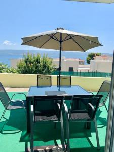 einen Tisch und Stühle mit Sonnenschirm auf einer Terrasse in der Unterkunft Apartment Mandarina in Dugi Rat