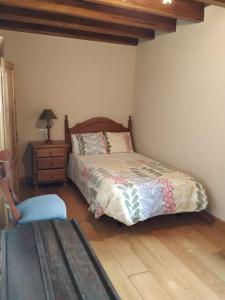 a bedroom with a bed and a table and a chair at Casa barrio el Reloj - Lastres in Lastres