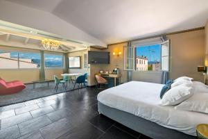 a hotel room with a bed and a dining area at Hotel POZZO DI BORGO in Ajaccio