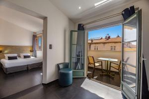 a hotel room with a bed and a room with a view at Hotel POZZO DI BORGO in Ajaccio