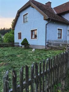 a blue house with a fence in front of it at Landhaus auf der Alm 