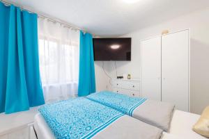 a bedroom with blue curtains and a bed at Barbarosa Sweet Dream 1 in Budapest