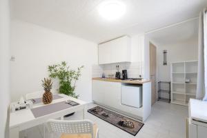 a kitchen with white cabinets and a counter top at Barbarosa Sweet Dream 1 in Budapest