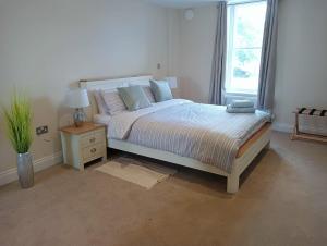 a white bedroom with a bed and a window at Executive Barchester House Apartment in Salisbury
