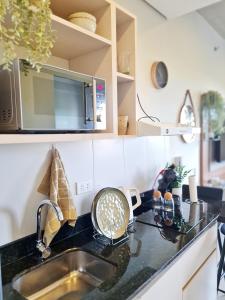 a kitchen counter with a sink and a microwave at Exclusivo mono para 4 personas in Luque