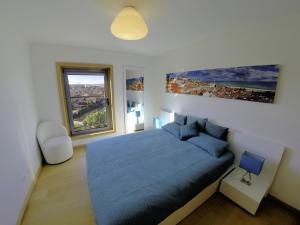 a bedroom with a blue bed and a large window at Finest Rentals - Expo Riverside in Lisbon