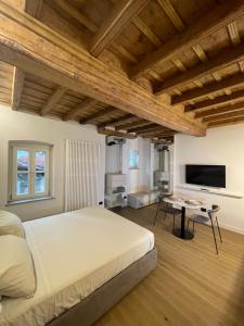 a bedroom with a large bed and a flat screen tv at La Dimora del Brocante in Cuneo