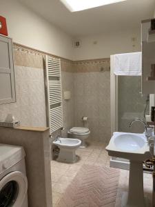 een badkamer met een toilet, een wastafel en een wasmachine bij La Casa di Mimì in Foligno