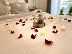 Una jaula de aves con velas y flores en una cama en Élégance et romantisme au cœur de la ville située sur la place de Lices - Le Port Vannes, en Vannes