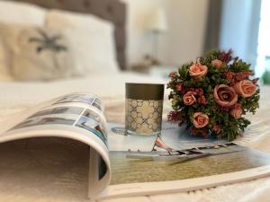 un libro y un jarrón de flores en una cama en Élégance et romantisme au cœur de la ville située sur la place de Lices - Le Port Vannes, en Vannes