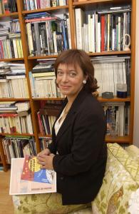 a woman is holding a book in a library at Villa Schiller, 2 studios côté jardin - quartier Orangerie in Strasbourg