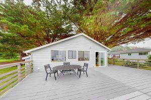 un patio con tavolo, sedie e una casa di Saddle Point Ocean View Cottage a Elk