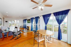 una sala da pranzo con tende blu e tavolo e sedie di Saddle Point Ocean View Cottage a Elk Altre 23 foto