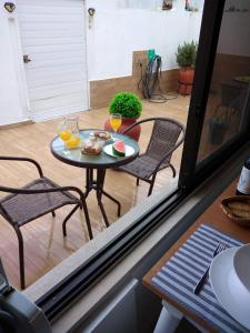 a table with two chairs and two glasses of orange juice at JB House in Nazaré +5 photos