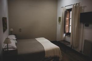 1 dormitorio con cama y ventana en Hotel Yacanto en Yacanto