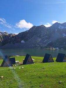 a group of lodges in a field next to a lake at Mountain cottage Captain's Lake, Kapetanovo jezero in Kolašin