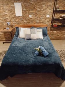 a large bed with a blue blanket and pillows at Aparta estudio Xenia in Bogotá