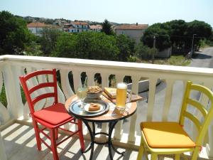 a table and chairs on a balcony with food and drinks at Villa Ines in Jezera