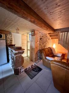 - un salon avec un canapé et une cheminée en pierre dans l'établissement Maison reposante, à Saint-Alyre-ès-Montagne