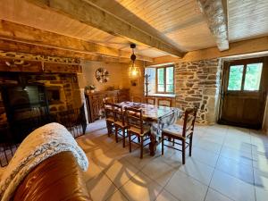a dining room with a table and chairs and a stone wall at Maison reposante in Saint-Alyre-ès-Montagne