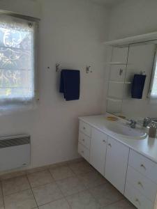 a white bathroom with a sink and a mirror at Maison avec jardin clos dans cité de caractère in La Roche-Derrien