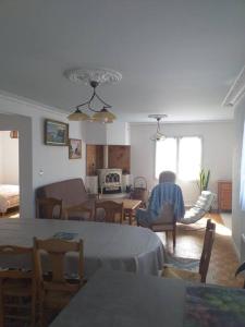 a living room with a person sitting in a chair at Maison avec jardin clos dans cité de caractère in La Roche-Derrien