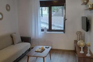 a living room with a couch and a table and a window at 4 Season Cozy Home in Samothraki