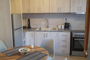 a kitchen with a table and a sink and a refrigerator at 4 Season Cozy Home in Samothraki