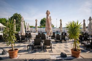Unique Garden Hotel في برايلا: فناء به طاولات وكراسي ومظلات