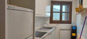 a small kitchen with a sink and a refrigerator at El Capricho de Bego in Biescas