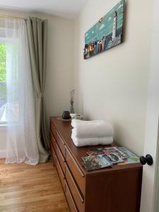 a room with a dresser with a picture on the wall at Tantallon Guest Room with Private Beach in French Village