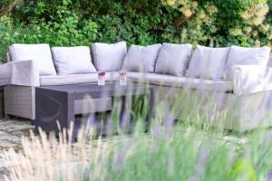 a couch sitting on a table in a garden at Fruska Pool House in Sremska Kamenica