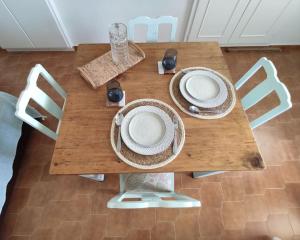 una mesa de madera con platos y sillas. en Village View House, en Galissas