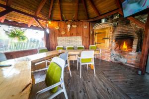 a dining room with a table and chairs and a fireplace at Miodowe Łoże in Woźnice