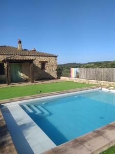 - une piscine en face d'une maison dans l'établissement Casa Rural La Vega, à San Vicente de Alcántara