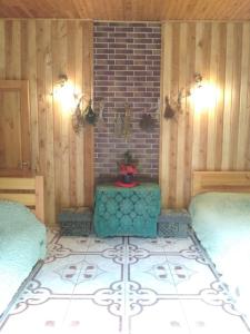 a room with two beds and a table and a brick wall at Світязький хуторок in Svityazʼ