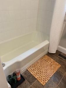 a white bath tub in a bathroom with a tile floor at Tantallon Guest Room with Private Beach in French Village