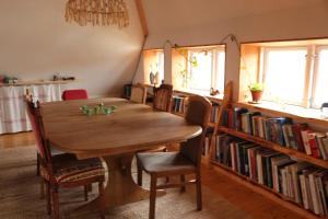 a dining room with a table and a book shelf with books at Heimaey, Ljósheimar in Passee