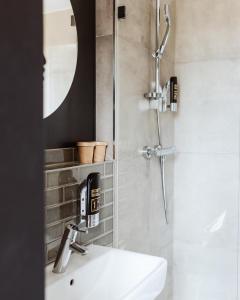 uma casa de banho com um chuveiro e um lavatório. em Emma by Schulz Hotel Berlin Friedrichshain em Berlim