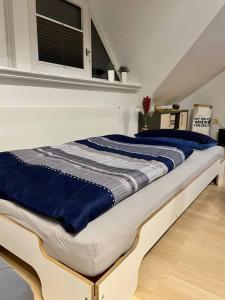 ein Bett mit blauer Bettwäsche auf einem Zimmer in der Unterkunft Studio freundlich & modern im Herzen von Bochum in Bochum