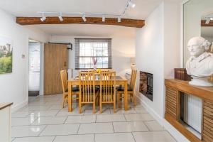 eine Küche und ein Esszimmer mit einem Tisch und Stühlen in der Unterkunft Bard's Cottage in Alcester