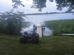 een vierwieler geparkeerd voor een meer bij Agroturystyka u Basi in Burniszki
