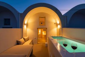 a room with a tub with two glasses of wine at RockHill Luxury Suite Imerovigli in Fira