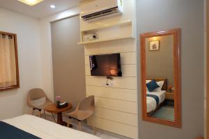 Habitación de hotel con cama y espejo en V.A TOURIST RESIDENCY en Taliparamba