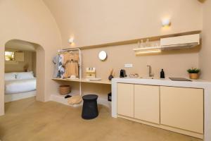 a kitchen with a sink and a bed in a room at RockHill Luxury Suite Imerovigli in Fira +18 photos