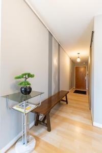 un couloir avec un banc en bois et une table dans l'établissement Le Royal 4* – Grand Confort Salle de Sport privée, à Vandœuvre-lès-Nancy