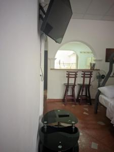 ein Wohnzimmer mit einem TV und einem Tisch in der Unterkunft Casa azul in Armenia