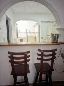 zwei Stühle an einer Theke in einer Küche in der Unterkunft Casa azul in Armenia