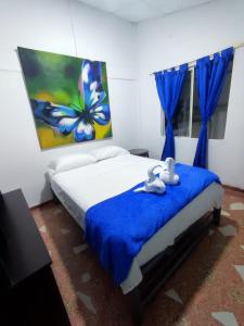 ein Schlafzimmer mit einem Bett mit zwei ausgestopften Tieren darauf in der Unterkunft Casa azul in Armenia