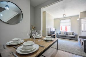 a living room with a table with glasses and a mirror at Stay with Alexandra in Liverpool